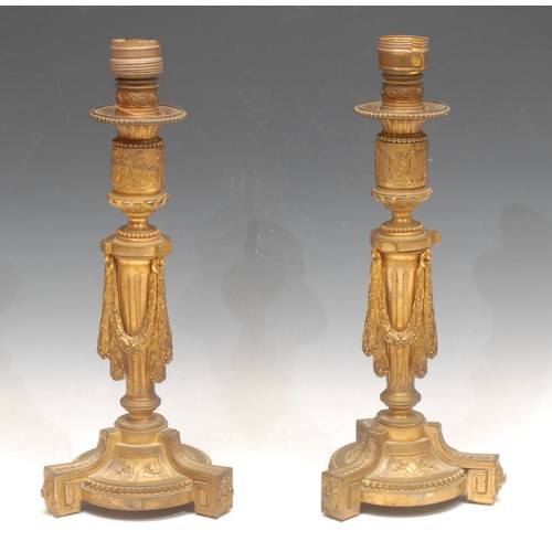 3163 - A pair of Louis XVI Revival ormolu candlesticks, later fitted as table lamps, the collars cast with ... 