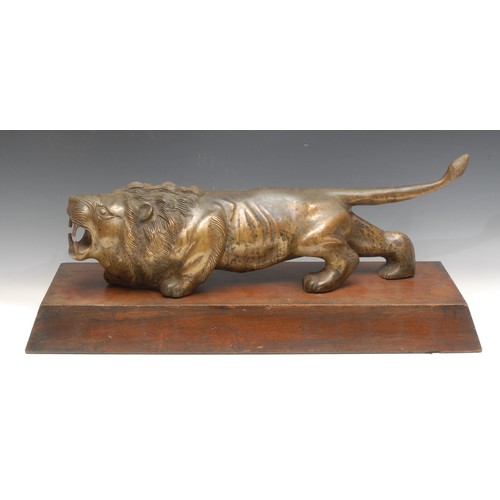 3345 - Art Deco School, a large gilt patinated bronze, of a lion, prowling, hardwood base, 63cm long