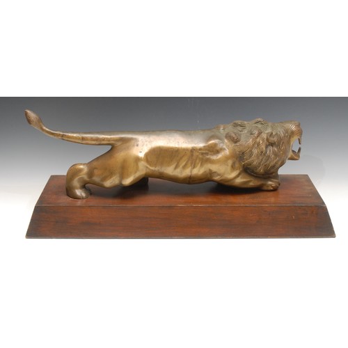 3345 - Art Deco School, a large gilt patinated bronze, of a lion, prowling, hardwood base, 63cm long