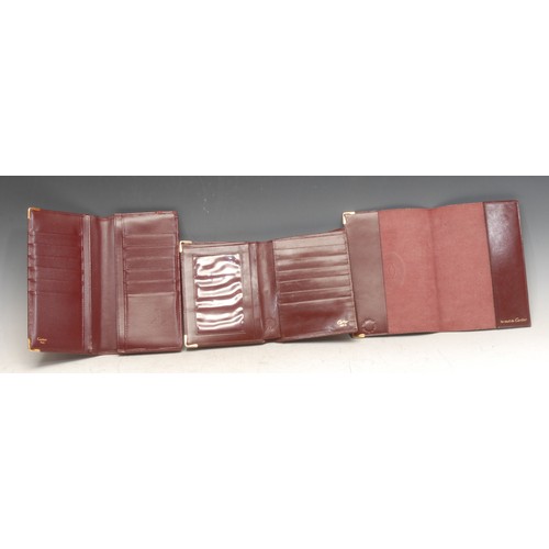 3628 - Cartier - a red leather wallet, folding front enclosing zip and an arrangement of compartments, 18.5... 