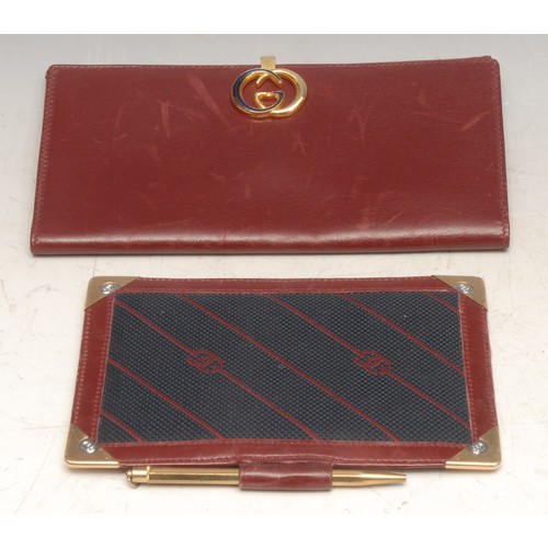 3630 - Gucci - a red leather wallet, monogram clasp, 17.5cm wide; an aide memoire, 14cm long (2)