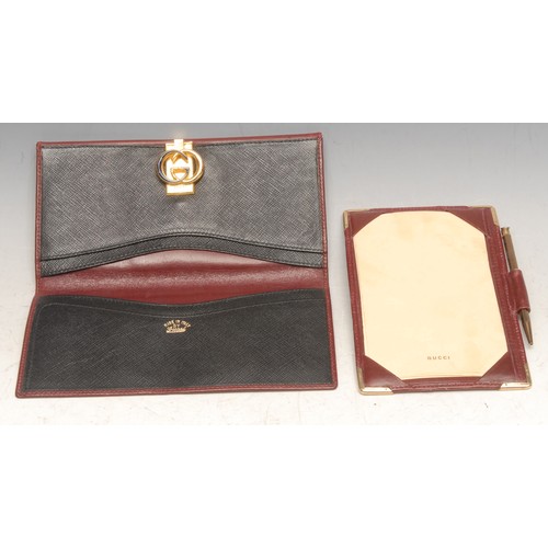 3630 - Gucci - a red leather wallet, monogram clasp, 17.5cm wide; an aide memoire, 14cm long (2)