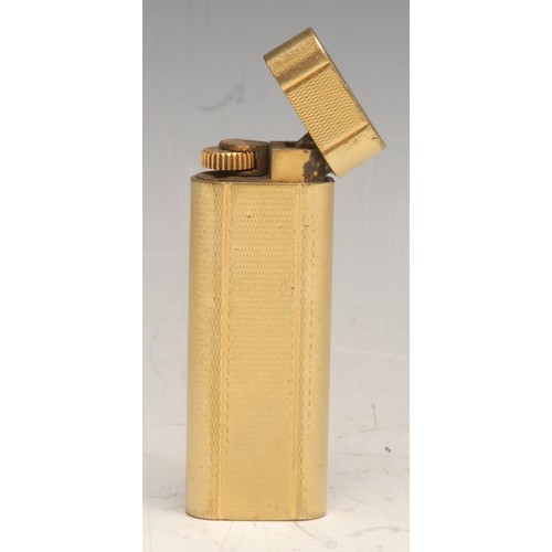 3627 - Cartier - a gilt metal cigarette lighter, engine turned, serial no. N51363, 7cm long