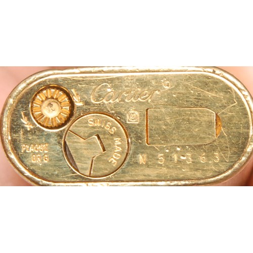 3627 - Cartier - a gilt metal cigarette lighter, engine turned, serial no. N51363, 7cm long