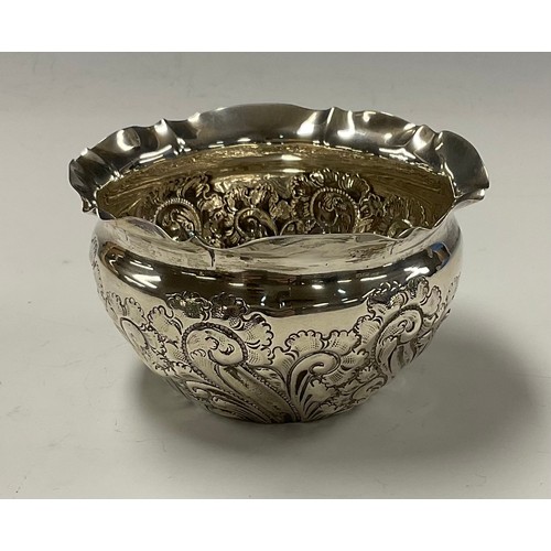 45 - A late Victorian silver bowl, chased with foliate scrolls, shaped rim, 6cm high, Sheffield 1900, 77g