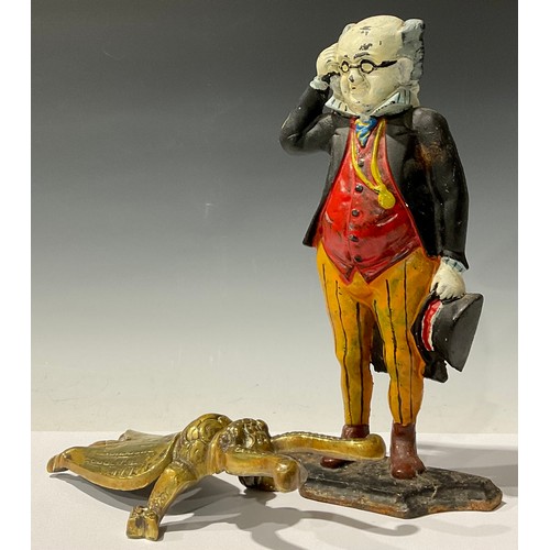 99 - A painted cast iron doorstop, modelled as Mr Pickwick, 36cm high; a brass boot jack, modelled as a b... 