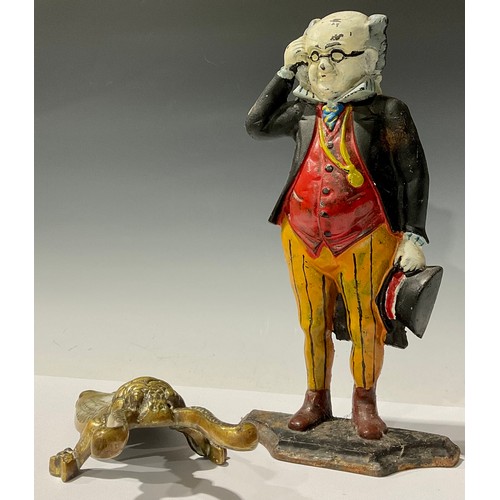 99 - A painted cast iron doorstop, modelled as Mr Pickwick, 36cm high; a brass boot jack, modelled as a b... 