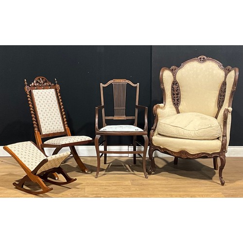 202 - A Louis XV style wing chair; a late Victorian rosewood and mahogany campaign-type chair; an Edwardia... 