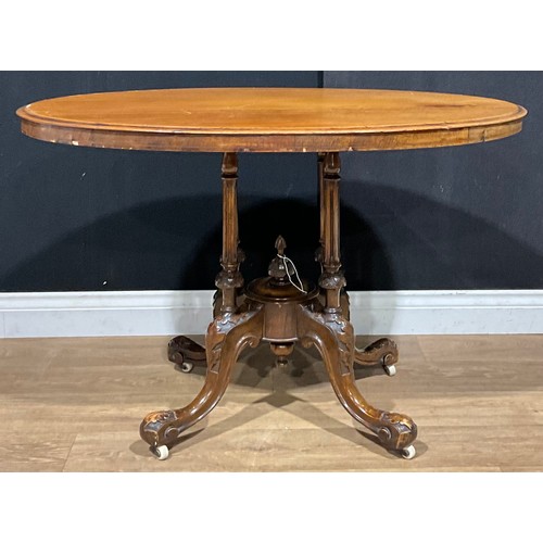 214 - A Victorian walnut and mahogany centre table, oval top with moulded edge, fluted supports centred by... 