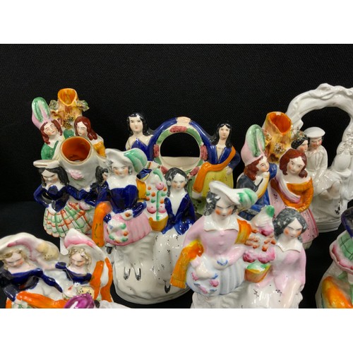 151 - A group of 19th century Staffordshire flat backs including; courting couples spill vases, dancing gi... 