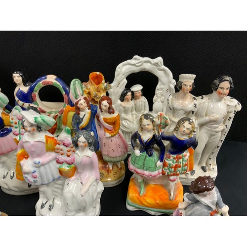 151 - A group of 19th century Staffordshire flat backs including; courting couples spill vases, dancing gi... 