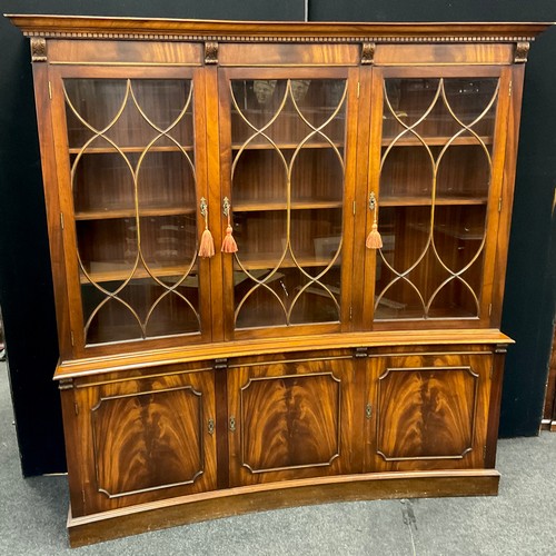 312 - A mahogany inverted bow front display cabinet, dentil cornice, three astral-glazed doors to top, enc... 