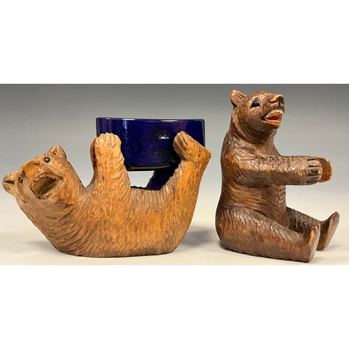 321 - A late 19th/early 20th century Black forest Bear table salt, carved lying on his back holding a blue... 