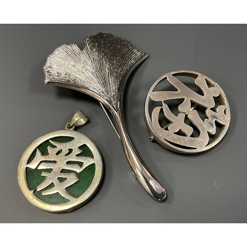 442 - A Japanese silver OHNO brooch;  green stone and silver character pendant etc (3)