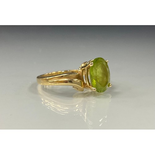 485 - A Princess Cruises Peridot twist ring, oval peridot quarter claw set within 14 ct gold shank, stampe... 