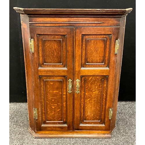 68 - A 19th century oak wall hanging corner cupboard, four panel doors, brass H hinges, 98cm x 76cm x 43c... 