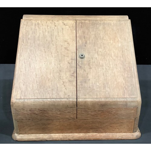 152 - A Victorian oak slope front stationery box, hinged covers enclosing calendar, shaped terraced divisi... 