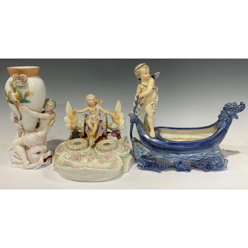 60 - A 19th century German porcelain inkstand, surmounted with a winged putti in winged chariot, above tw... 