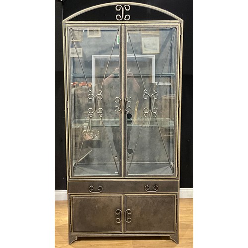 102 - A contemporary patinated sheet metal display cabinet, arched cresting above a pair of glass doors, a... 