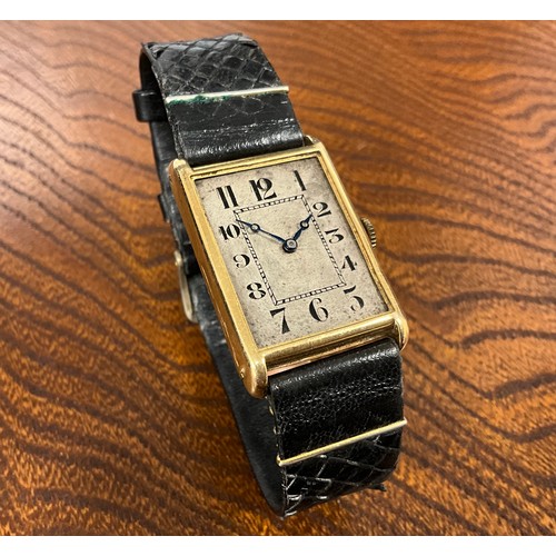 1045 - A 1920s gold cased wristwatch, rectangular silver dial, Arabic numerals, inner minute track, blued h... 