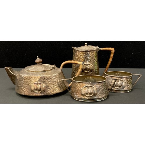 66 - An Arts and Crafts pewter four piece tea set, hammered and embossed body with Archibald Knox style r... 