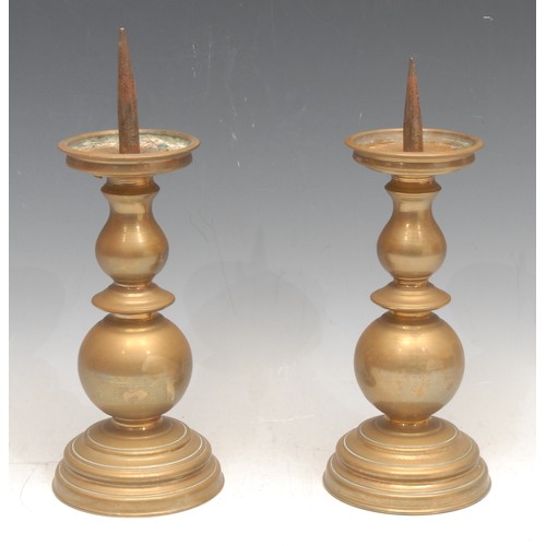 81 - A pair of short 19th century Continental brass pricket candlesticks, knopped stems, stepped circular... 