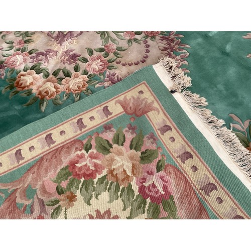 190 - A Chinese Shensi deep pile woolen rug, in rich jade green, with floral medallion and corners in tone... 