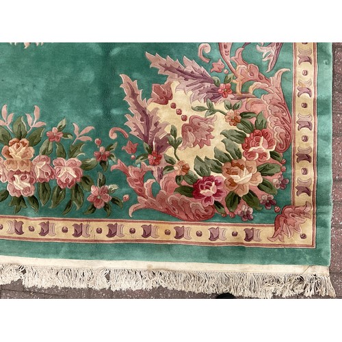 190 - A Chinese Shensi deep pile woolen rug, in rich jade green, with floral medallion and corners in tone... 