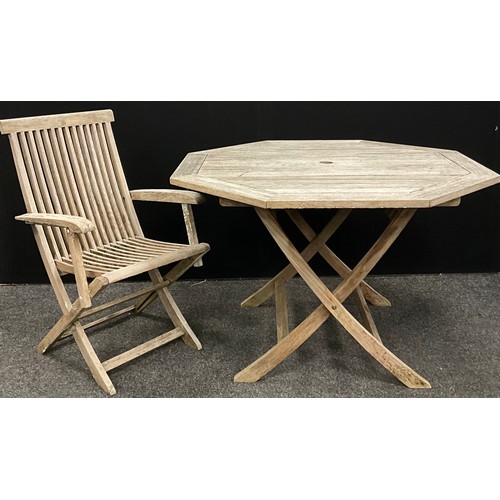 218 - A weathered Teak folding octagonal garden table, 74cm high x 112cm wide;  a conforming folding garde... 