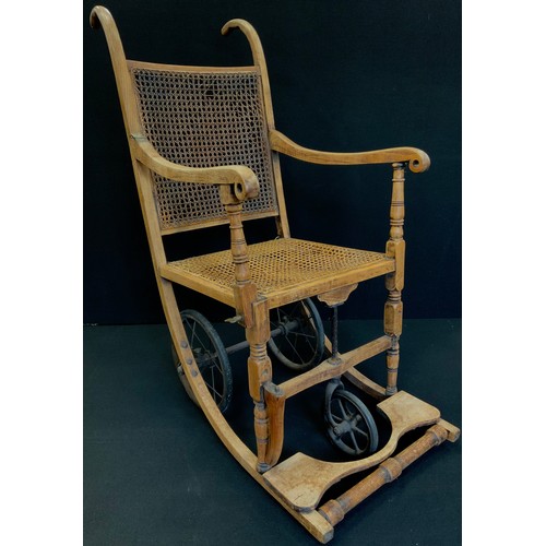 229 - A late 19th century oak framed wheel chair, cane work seat and back, with makers plaque to rear 'Joh... 