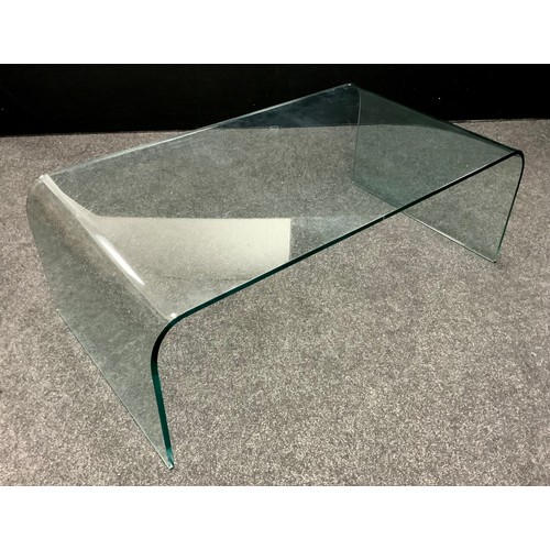 104 - Interior design - A modern design curved clear glass coffee table, 38cm high x 110.5cm wide x 60cm d... 