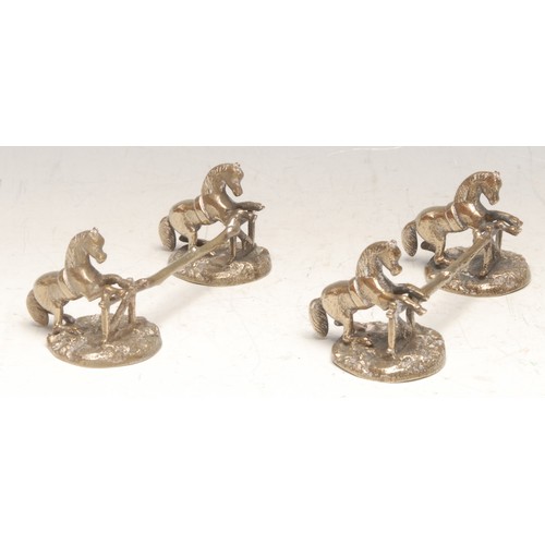 221 - A pair of 19th century electrotype knife rests, each modelled as horses leaping over a gate, on natu... 