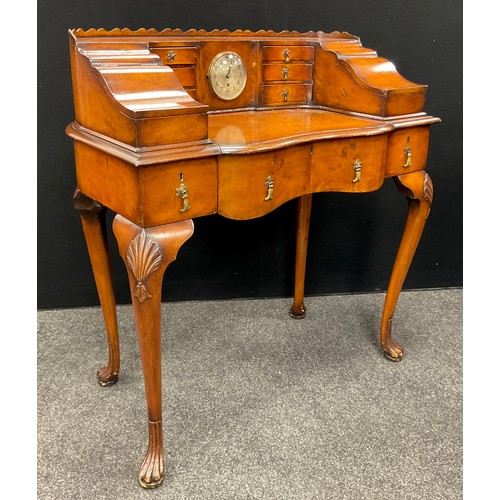 182 - A Carlton House style walnut writing desk, the galleried super structure set with clock to centre, f... 