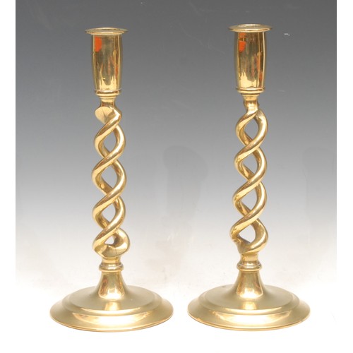 300 - A pair of early 20th century brass open twist candlesticks, circular bases, 25.5cm high