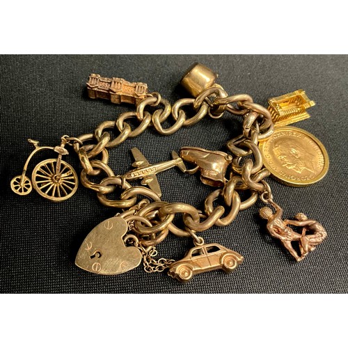 313 - A 9ct gold charm bracelet, nine charms inc 1914 half sovereign,  teapot, Boot, Plane, Buckingham Pal... 