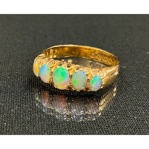 320 - An 18ct gold opal ring, liners set with five graduating oval opal cabochons, vibrant blue, gree nad ... 