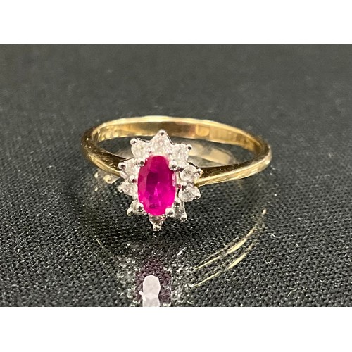 321 - A diamond and pink stone possibly ruby cluster ring, oval pink stoen surrounded by ten round brillia... 