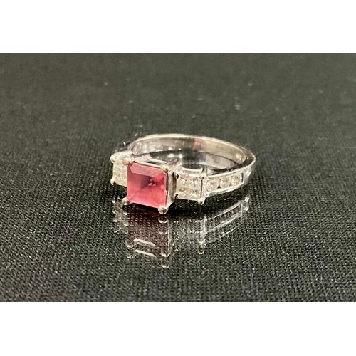 322 - A diamond and pale pink stone ring, central pink square stone, flanked by clusters of four princess ... 