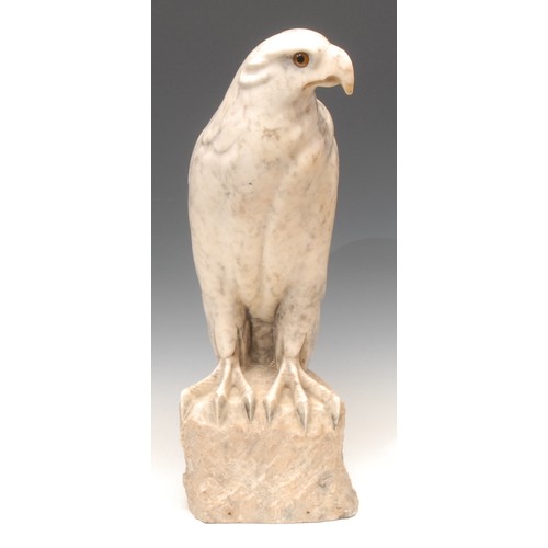 80 - A carved alabaster model, of an eagle, perched on a rocky outcrop, glass eyes, 46cm high, 20th centu... 