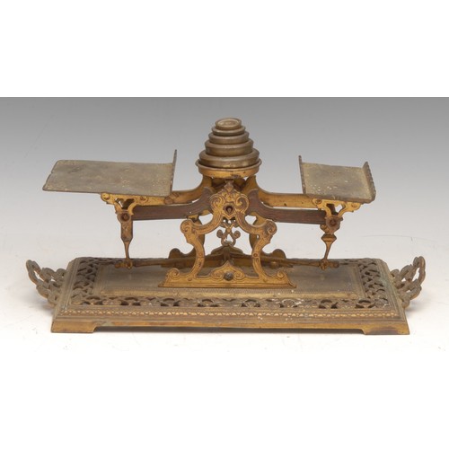 331 - A set of 19th century brass letter balance scales, pierced and engraved with leafy scrolls, carrying... 