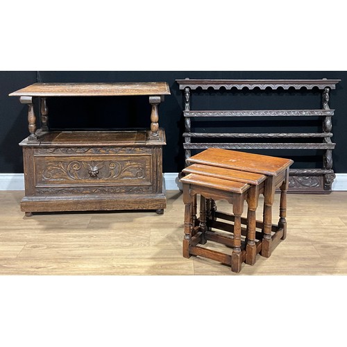 105 - An oak monk’s bench, 91.5cm wide; a Jacobean Revival oak wall rack, 112.5cm wide; an oak nest of thr... 