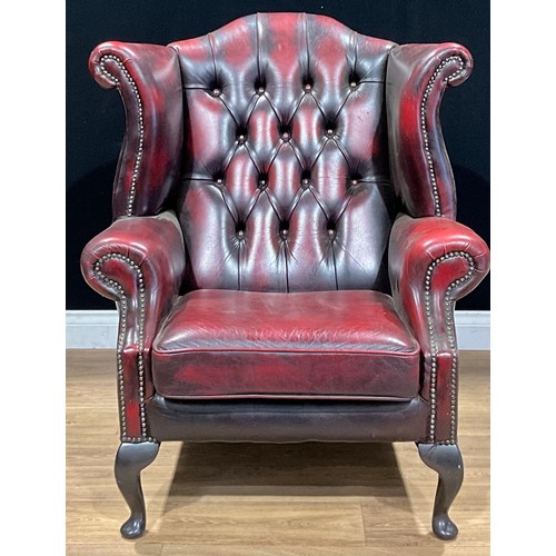 491 - A contemporary Chesterfield type wing armchair, 104cm high, 85cm wide, the seat 48cm wide and 44cm d... 