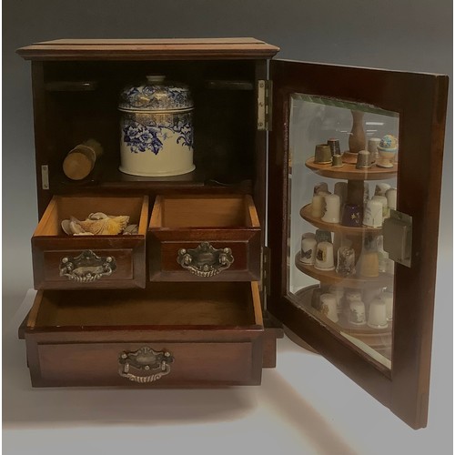 502 - An Edwardian mahogany smoker’s cabinet, the bevelled glass door enclosing a 19th century tobacco jar... 