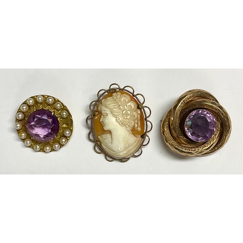 599 - A late 19th century 9ct gold circular brooch, set with a central faceted amethyst, surrounded by cul... 