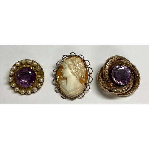 599 - A late 19th century 9ct gold circular brooch, set with a central faceted amethyst, surrounded by cul... 