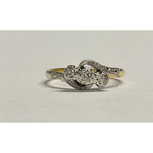 617 - An 18ct gold three stone diamond crossover ring, illusion set stones, platinum bezel, size L, 2.6g