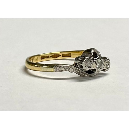 617 - An 18ct gold three stone diamond crossover ring, illusion set stones, platinum bezel, size L, 2.6g