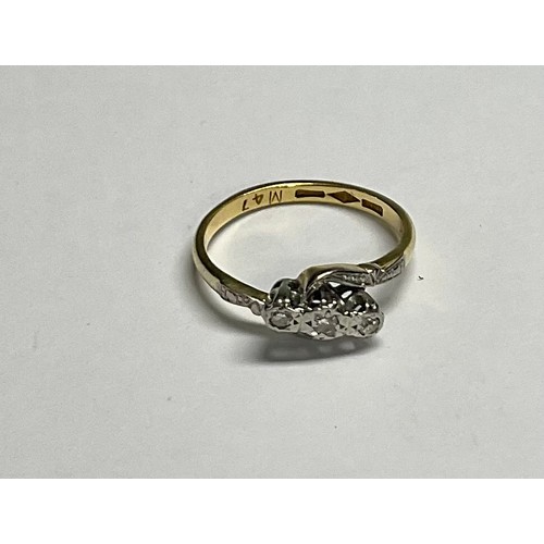 617 - An 18ct gold three stone diamond crossover ring, illusion set stones, platinum bezel, size L, 2.6g