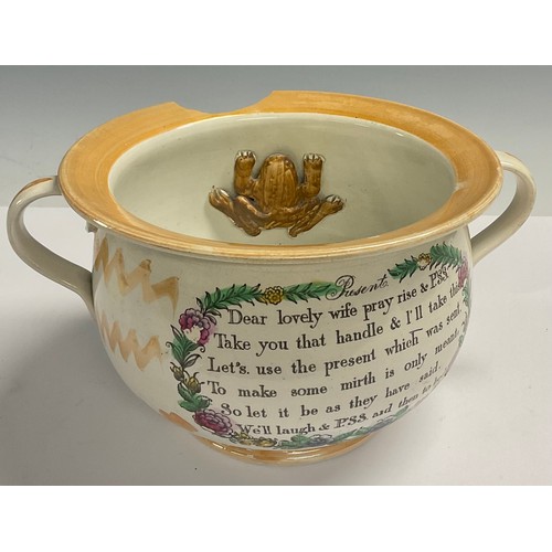 662 - An English lustre pottery marriage chamber pot, printed with verse, the interior with caricature and... 