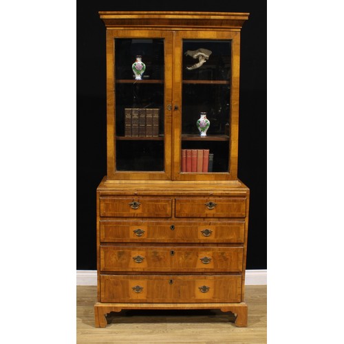 1360 - An 18th century and later walnut library bookcase, outswept cornice above a pair of glazed doors, en... 